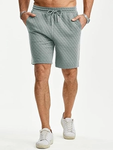 Macro shot of grey quilted fabric texture and diamond pattern on men drawstring shorts