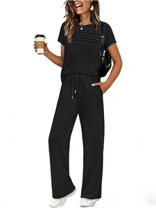 Detail of black two-piece set featuring pleated short sleeve top and wide-leg trousers