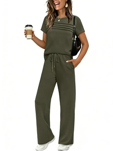 Detail of dark green two-piece set featuring pleated short sleeve top and wide leg pants
