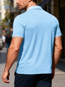 Rear view of a light blue short sleeve polo shirt with textured waffle knit fabric