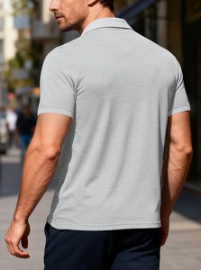 Close-up of light grey men's short sleeve polo shirt featuring piqué waffle texture