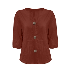 Detail of V-neckline with wooden buttons on women's loose cotton linen shirt in brick red