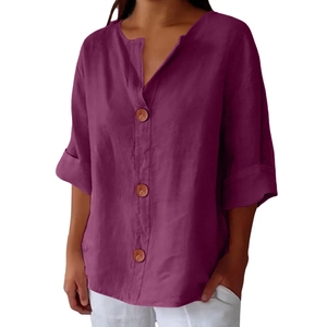 Detail of V-neck linen shirt in purple-red with natural wooden buttons and rolled sleeves
