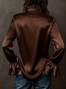 Détail du dos d'une élégante chemise en satin marron avec manches évasées et tissu brillant