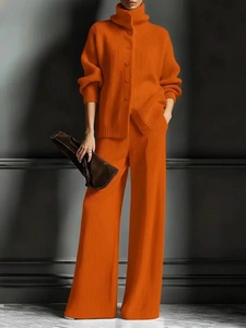 Detail eines orangefarbenen Rippstrick-Zweiteilers mit Rollkragen-Strickjacke und weiter Hose