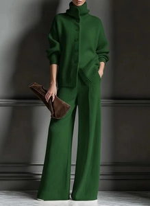 Detailed view of dark green ribbed knit texture on high neck cardigan and wide leg pants
