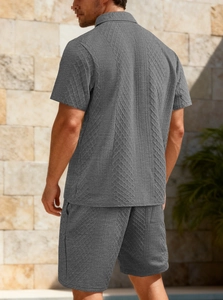 Close-up of dark grey men's polo set showing intricate textured jacquard knit fabric