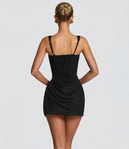 Detailed back view of a black bodycon dress featuring stylish corset-style lace-up straps