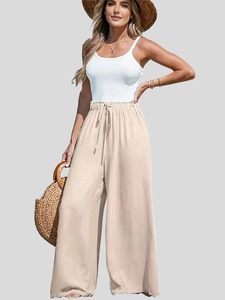 Dettaglio dei pantaloni larghi in cotone e lino a vita alta con coulisse in tinta beige