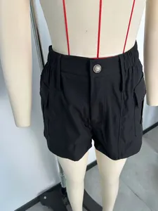 Detailweergave van zwarte cargoshorts met hoge taille, elastische tailleband en knoopsluiting