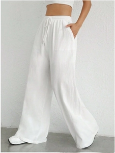 Detail of white wide-leg trousers featuring drawstring waist and textured fabric