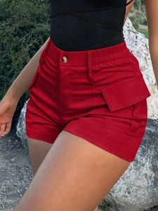 Detail van rode cargo shorts met hoge taille met zijzakken en metalen knoopsluiting