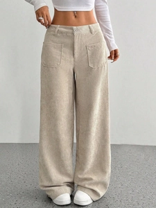 Dettaglio dei pantaloni a gamba larga in velluto a coste beige con tasche applicate anteriori