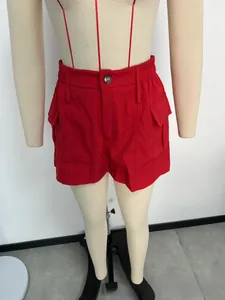 Detail van rode cargo shorts met elastische taille, klepzakken en knoopaccenten