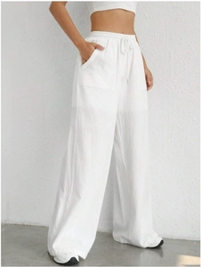 Detail of white wide-leg trousers showing drawstring waist and functional square pockets