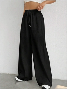 Detail of black drawstring waist and side pocket on casual straight-leg trousers