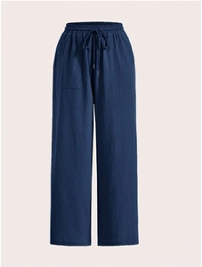 Detail of navy blue wide-leg trousers showing drawstring waist and natural linen texture