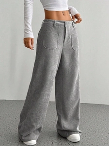 Dettaglio dei pantaloni larghi in velluto a coste grigio con grandi tasche applicate