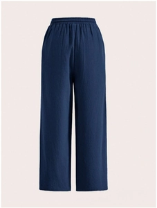 Detail of navy blue wide-leg pants showing elastic waistband and textured fabric detail