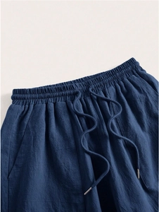 Detail of navy blue high elastic drawstring waistband with metal tips on linen trousers