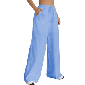 Detail of light blue wide-leg trousers showing elastic drawstring waist and large patch pockets