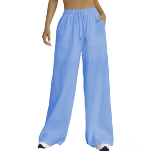 Detail of light blue wide-leg trousers showing elastic drawstring waist and large pockets