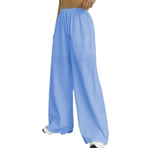 Detail of light blue wide-leg trousers showing drawstring waist and textured fabric