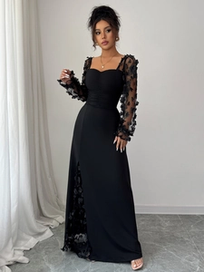 Detail of elegant black lace dress with floral applique sheer sleeves and side slit design