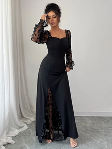Detail of elegant black lace dress with 3D floral appliques on sheer puff sleeves