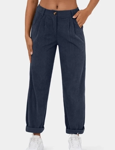Detailopname van een donkerblauwe corduroy broek met hoge taille, plooien en knoop