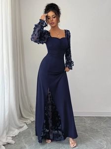 Detailed view of the 3D floral lace appliques and mesh sleeves on this navy evening gown