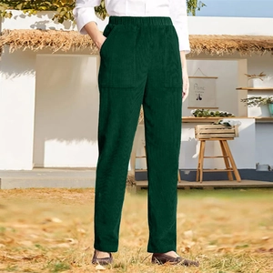 Detail of dark green corduroy trousers with elastic high waist and large patch pockets