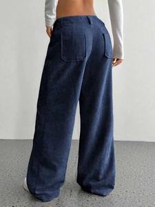 Dettaglio dei pantaloni a gamba larga in velluto a coste con tasche posteriori blu scuro