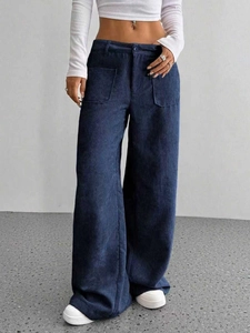 Dettaglio delle tasche a toppa quadrate su pantaloni a gamba larga in velluto a coste blu scuro