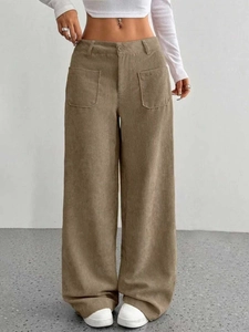 Dettaglio dei pantaloni di velluto a coste a vita alta con ampie tasche quadrate anteriori