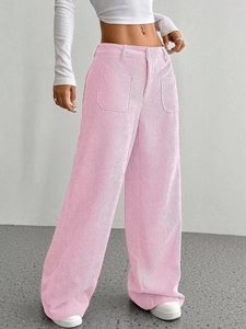Dettaglio dei pantaloni a gamba larga in velluto a coste rosa con tasche e trama morbida