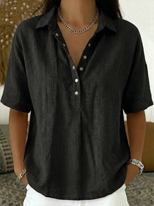 Détail d'une chemise en coton et lin noire avec des boutons argentés et un col à revers
