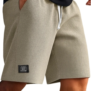 Men's khaki waffle knit shorts featuring elastic waistband and contrast drawstrings