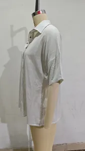 Détail de la texture du tissu en lin blanc et de la fente latérale de l'ourlet