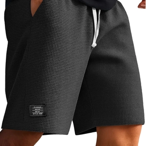 Men's dark gray waffle knit sports shorts with white drawstring and patch detail