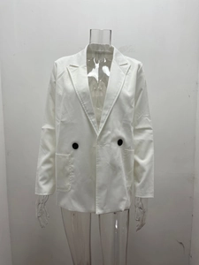 Detail of white double-breasted blazer with black buttons and notched lapel pockets