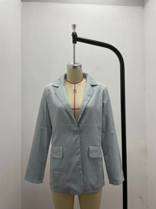 Detail view of light blue notched lapel blazer with single button and flap pockets