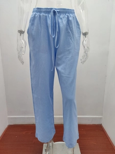 Detail showing elastic waist and drawstring design on light blue textured casual pants