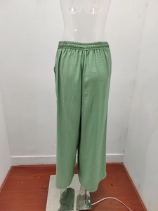 Dettaglio dei pantaloni a gamba larga verde erba con vita alta e coulisse elastica