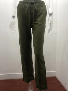 Detail of dark green cotton linen trousers with elastic drawstring waist and loose fit