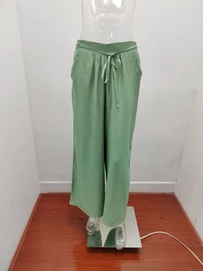 Dettaglio dei pantaloni larghi verde chiaro con vita elastica e coulisse funzionale