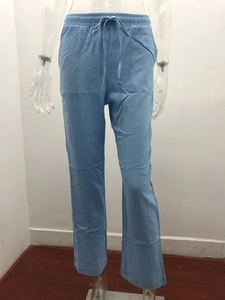 Detail view of light blue linen trousers with high waist drawstring and wide leg cut