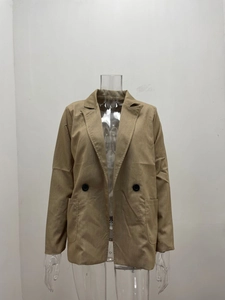 Detailed close-up of khaki blazer featuring notch lapels and black contrast buttons