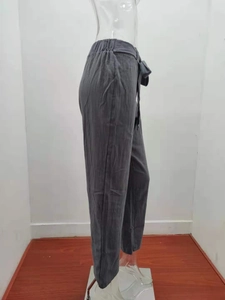 Detail of dark grey cotton linen trousers showing elastic waist and drawstring texture