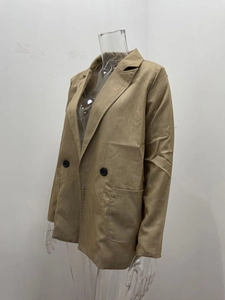 Detail of khaki double-breasted blazer showing lapel collar and flap pockets on mannequin